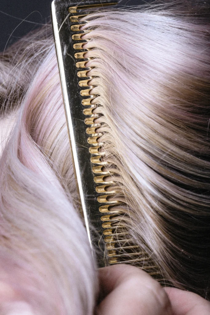 Zdjęcie złotych nożyczek fryzjerskich na tle włosów